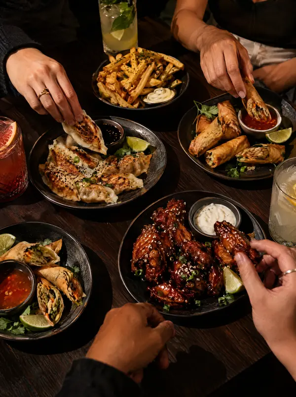 Freunde teilen Gyoza, Frühlingsrollen und Chicken Wings